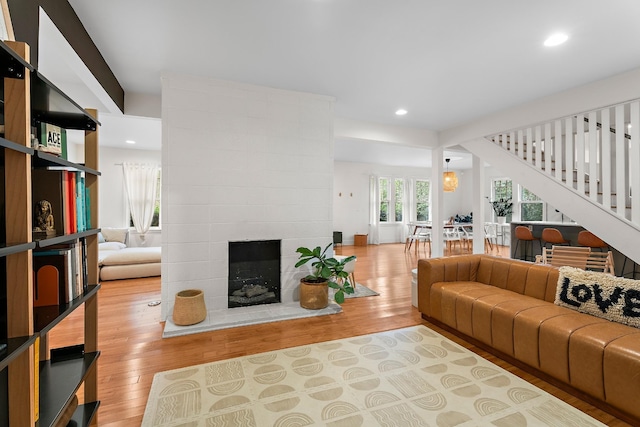 living room with a large fireplace and light hardwood / wood-style flooring