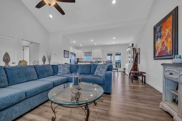 living room featuring high vaulted ceiling, light wood-type flooring, and ceiling fan