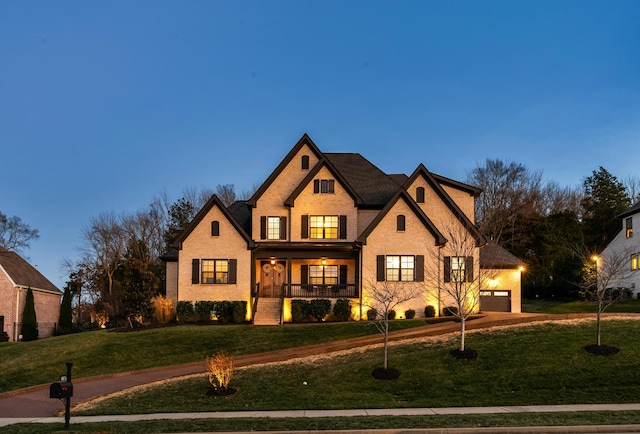 view of front of house featuring a porch, a yard, and a garage