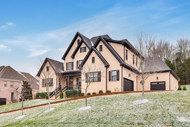 view of front of home with a front yard, a garage, and covered porch