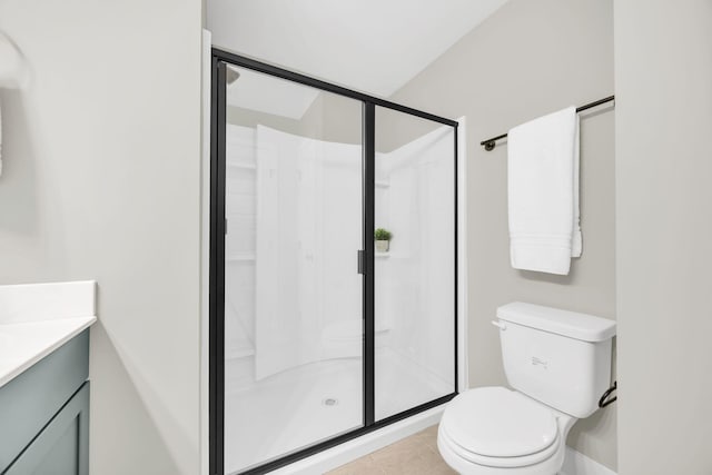 bathroom featuring toilet, tile patterned flooring, a shower with shower door, and vanity