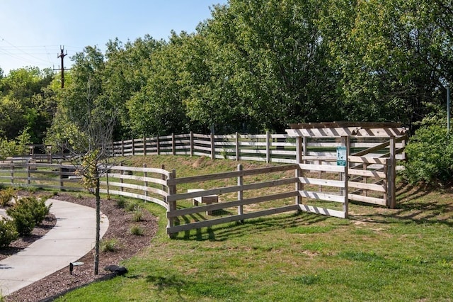 view of gate with a lawn