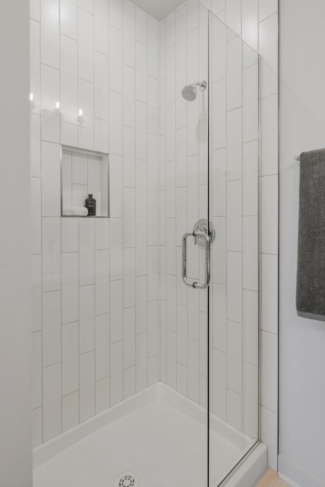 bathroom featuring a shower with shower door