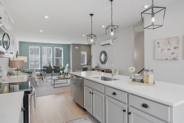 kitchen featuring sink, stainless steel appliances, light hardwood / wood-style flooring, and hanging light fixtures