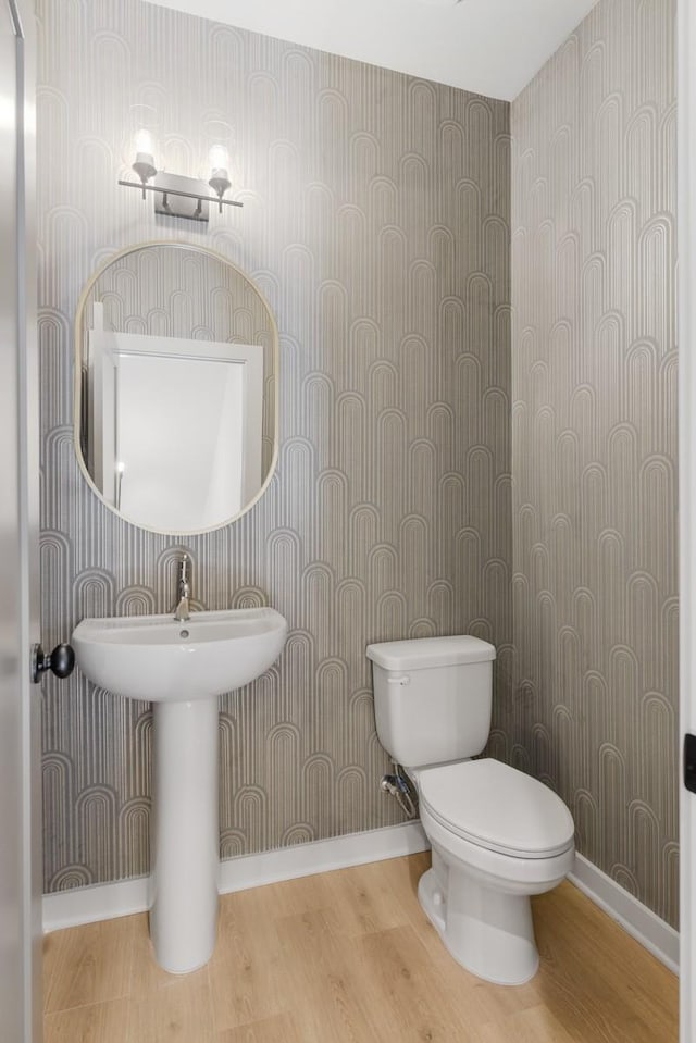 bathroom featuring toilet and wood-type flooring