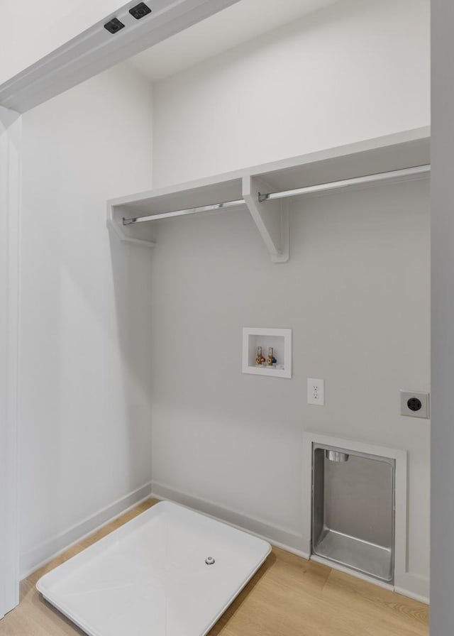 washroom featuring electric dryer hookup, hookup for a washing machine, and light hardwood / wood-style flooring