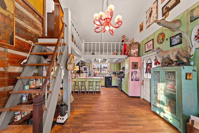 stairway featuring high vaulted ceiling, an inviting chandelier, and wood-type flooring