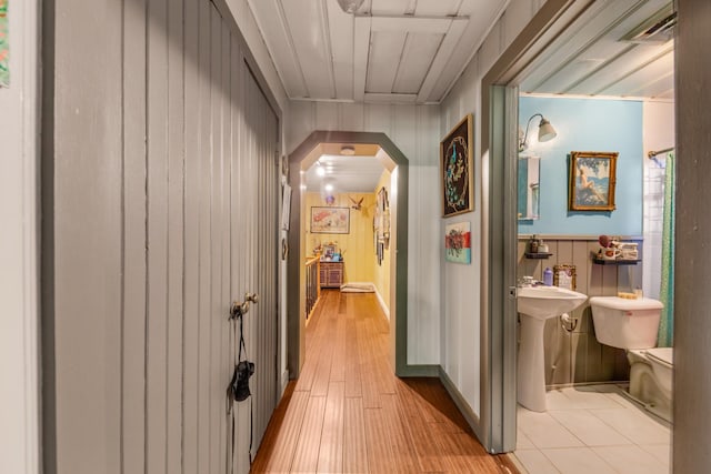 hallway with sink and wood walls