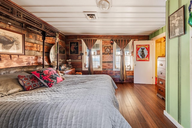 bedroom featuring dark wood-type flooring and wooden walls