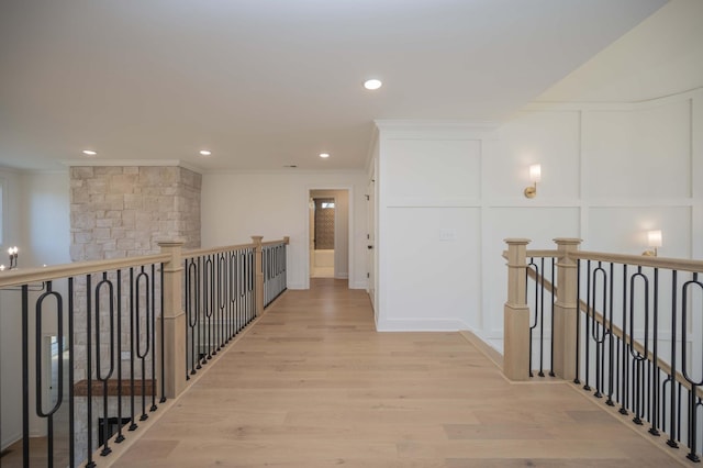 hall with light wood-type flooring and crown molding