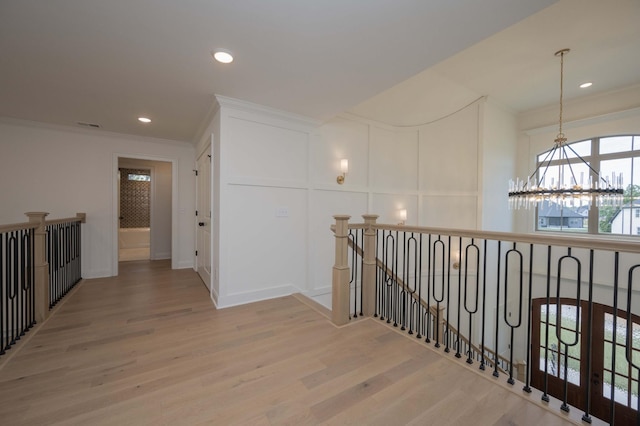 corridor featuring hardwood / wood-style floors, a chandelier, and crown molding