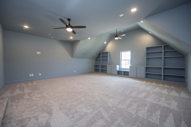 additional living space with lofted ceiling, carpet flooring, ceiling fan, and built in features