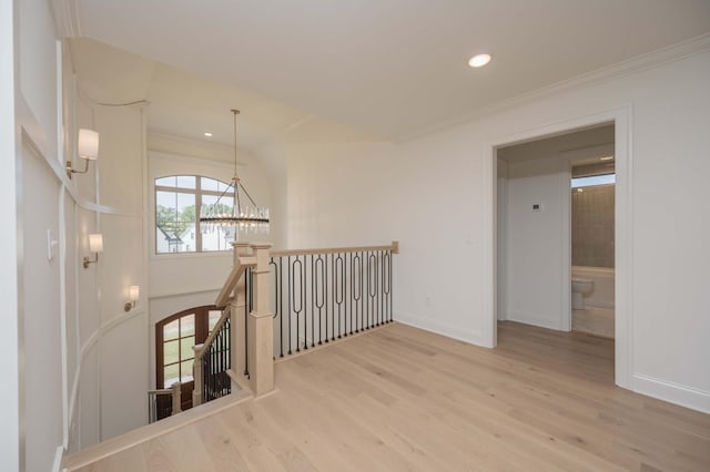 interior space featuring ornamental molding, light wood-type flooring, and a chandelier