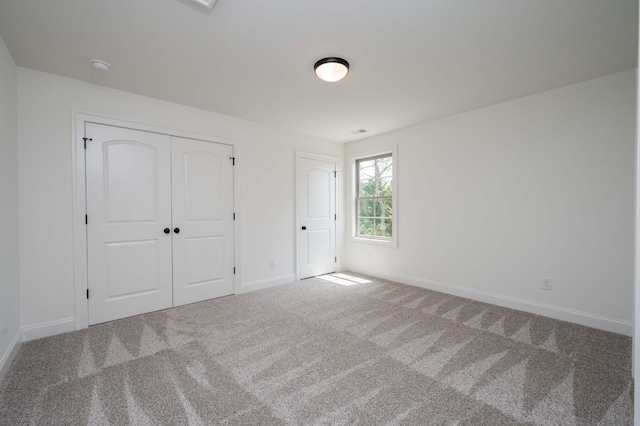 unfurnished bedroom with carpet flooring and a closet