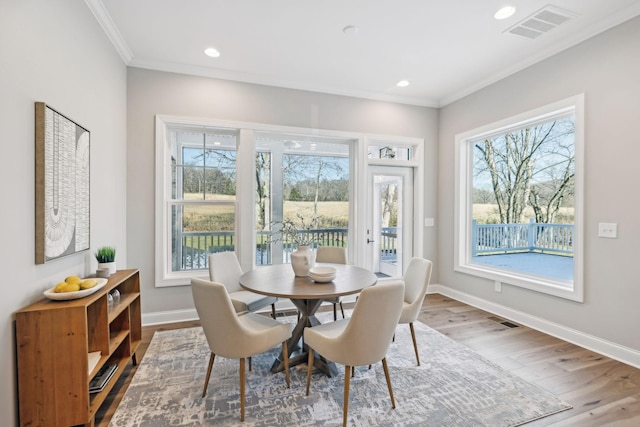 dining space featuring hardwood / wood-style flooring and ornamental molding