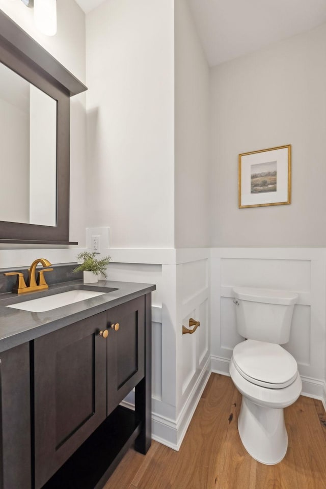 bathroom with toilet, hardwood / wood-style flooring, and vanity