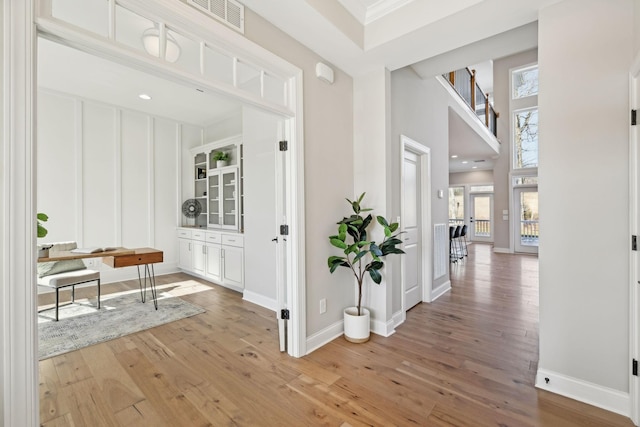 hallway with wood-type flooring and crown molding