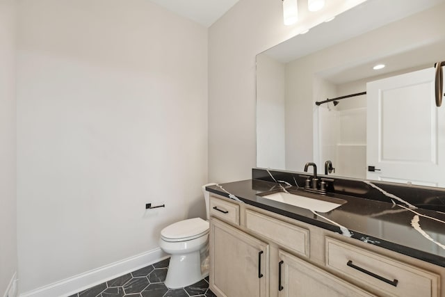 bathroom with toilet, a shower, and vanity