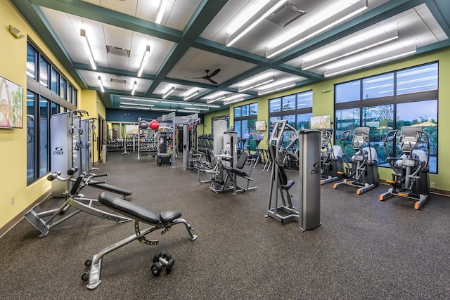 exercise room featuring coffered ceiling, ceiling fan, and a wealth of natural light