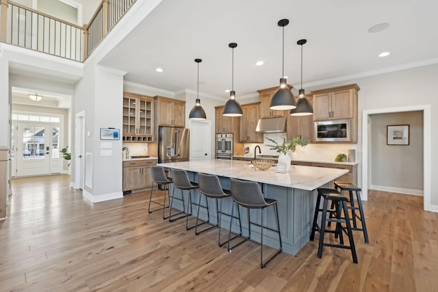 kitchen featuring light wood-type flooring, a spacious island, a breakfast bar area, hanging light fixtures, and high end refrigerator