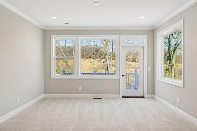 carpeted spare room featuring crown molding