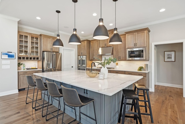 kitchen featuring stainless steel appliances, a large island, decorative light fixtures, a kitchen breakfast bar, and backsplash