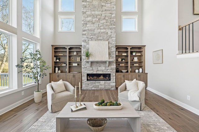 living room featuring a high ceiling, hardwood / wood-style floors, plenty of natural light, and a fireplace