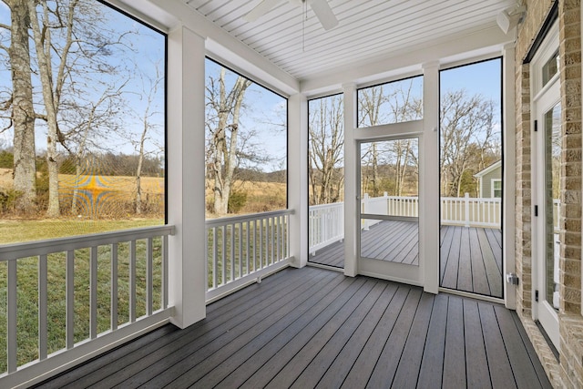 unfurnished sunroom featuring ceiling fan and a wealth of natural light