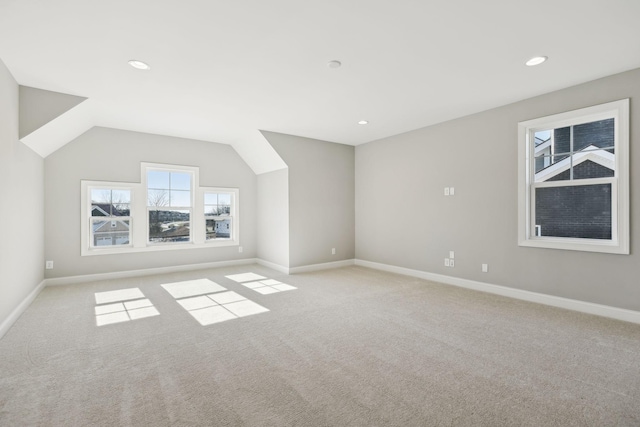 additional living space with lofted ceiling and light carpet