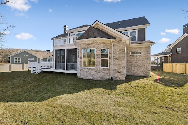 back of property with a balcony, a lawn, and a sunroom