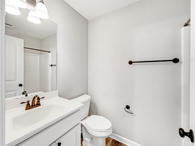 bathroom featuring toilet, a shower, hardwood / wood-style floors, and vanity