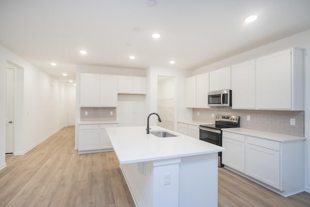 kitchen featuring appliances with stainless steel finishes, white cabinetry, and sink