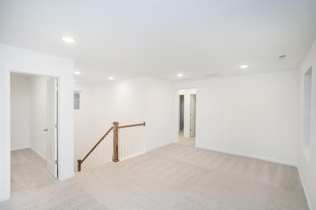 unfurnished room featuring light carpet