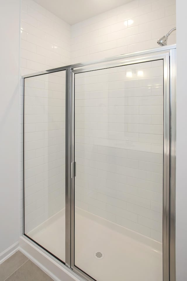 bathroom with tile patterned flooring and a shower with door