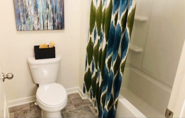 bathroom featuring shower / bath combo with shower curtain and toilet