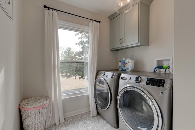 laundry room with cabinets, washing machine and dryer, and light tile patterned flooring