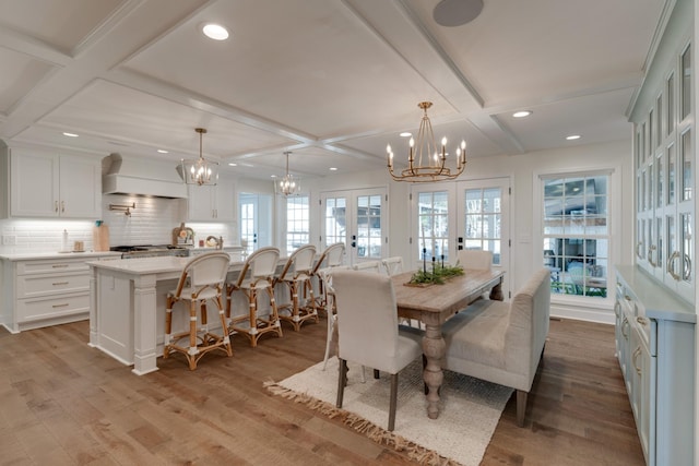 dining area featuring beam ceiling, french doors, coffered ceiling, and light wood-type flooring