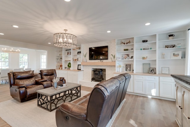 living room featuring light hardwood / wood-style flooring, an inviting chandelier, and a wood stove