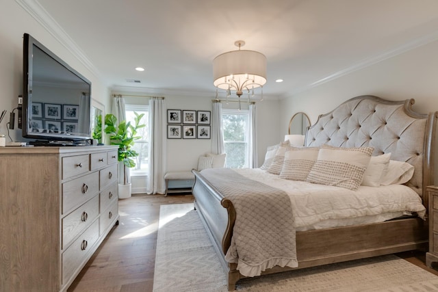 bedroom with ornamental molding and light hardwood / wood-style floors