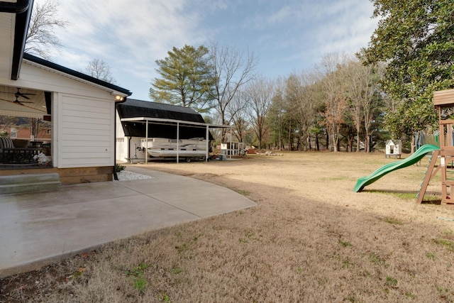 view of yard featuring a playground and a carport