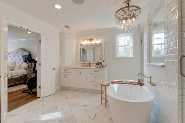 bathroom with vanity, a chandelier, crown molding, and a bathing tub