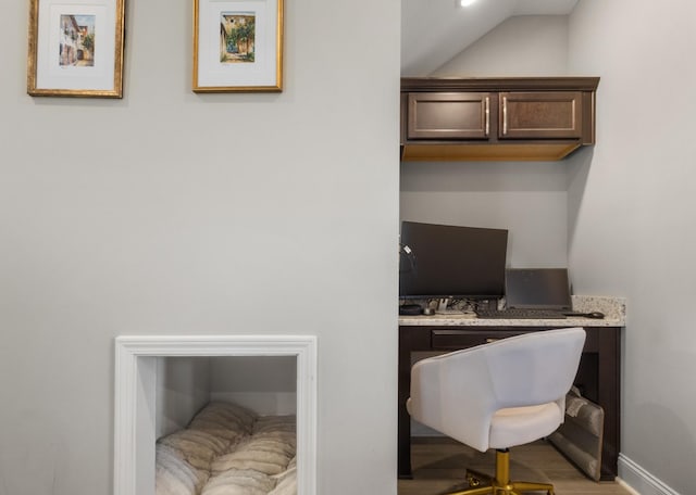 office area with light hardwood / wood-style floors and vaulted ceiling