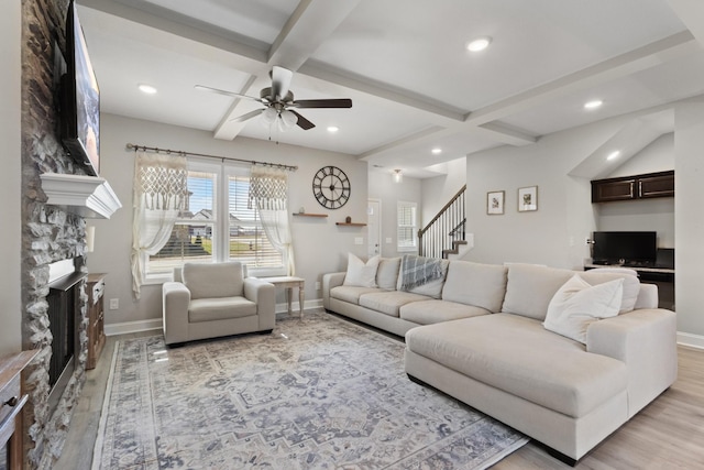 living room with a fireplace, beamed ceiling, light wood-type flooring, ceiling fan, and coffered ceiling