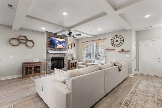 living room featuring a fireplace, ceiling fan, light hardwood / wood-style floors, and beam ceiling