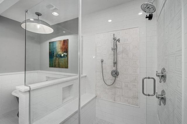 bathroom featuring tile walls and a shower with shower door