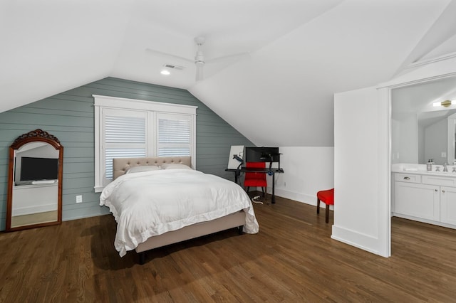 bedroom featuring ceiling fan, dark wood-type flooring, ensuite bath, and lofted ceiling