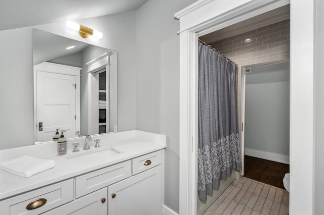 bathroom featuring toilet, vanity, and curtained shower