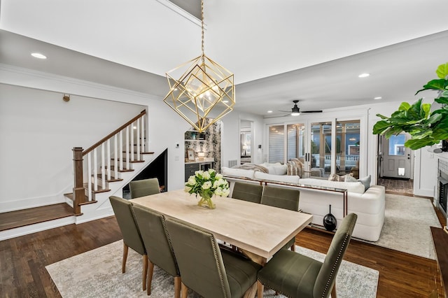 dining space featuring ceiling fan with notable chandelier and dark wood-type flooring