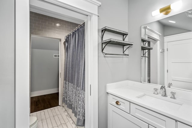 bathroom featuring toilet, vanity, and a shower with curtain