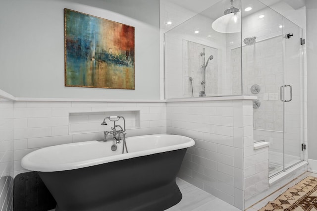 bathroom featuring tile walls and independent shower and bath